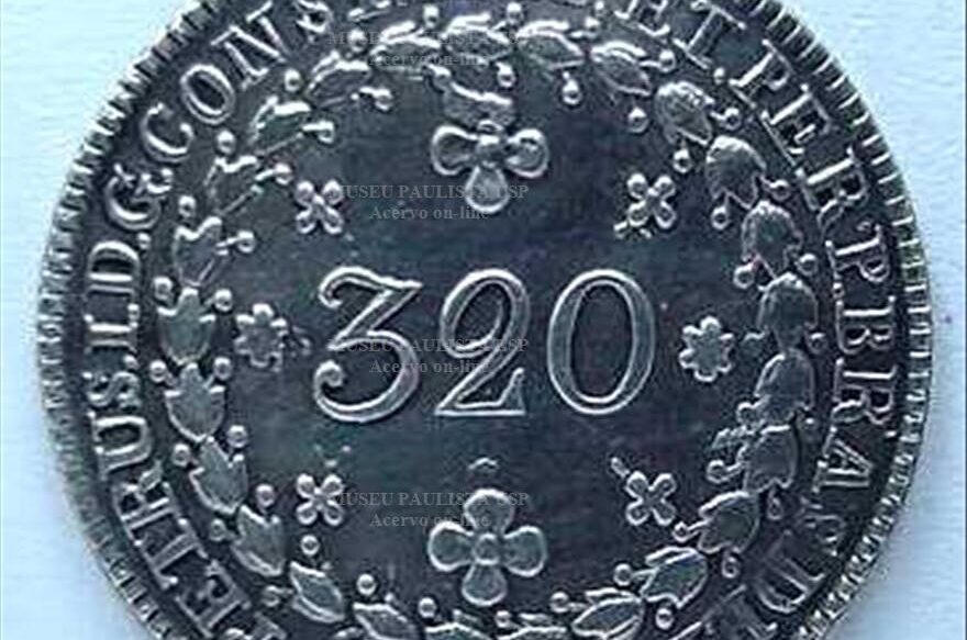 Moeda em formato arredondado na cor prata. Ao centro se lê "320". Há desenhos que remetem a flores, nos cantos da moeda.