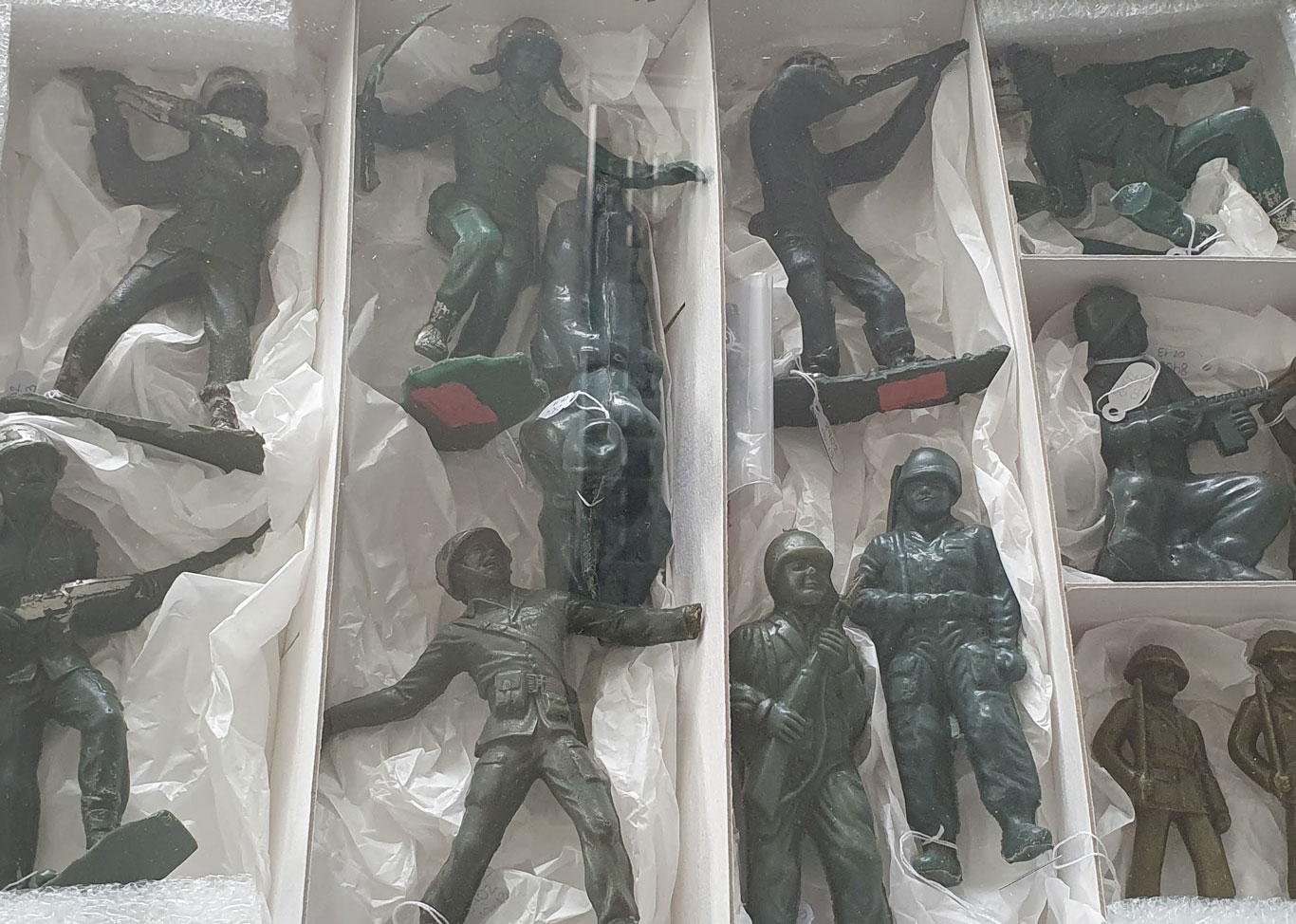 Box containing 12 toy soldiers. There are specimens pointing weapons or in different attack positions.