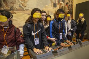 grupo de jovens com vendas tocando em objetos no Museu do Ipiranga